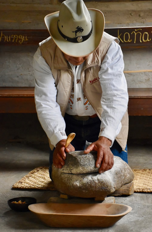 阿方索在石头上磨玉米“磨”。