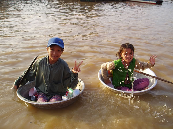 勤劳的孩子在湄公河上收集塑料和罐头