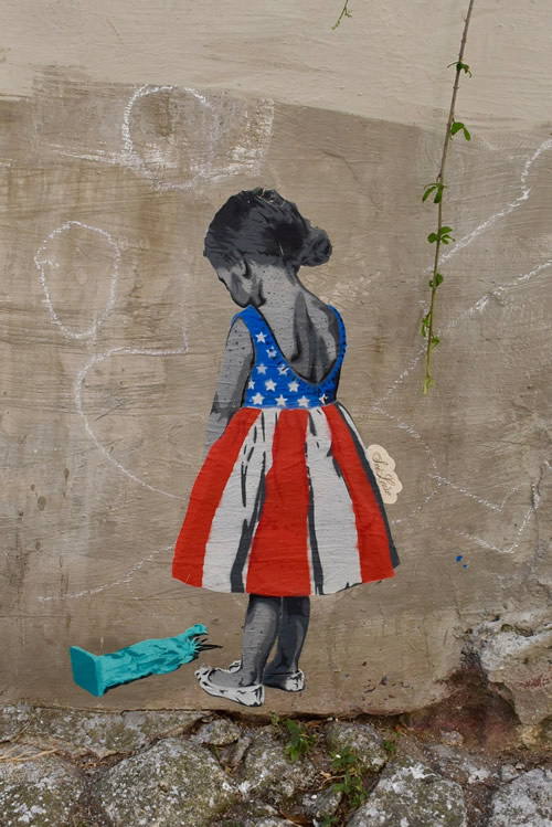 波尔图的城市街头艺术。女孩看着倒下的自由女神像的图像。