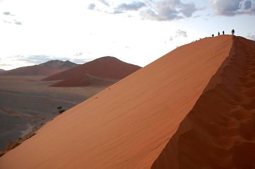 在纳米比亚组探险旅行爬上沙丘