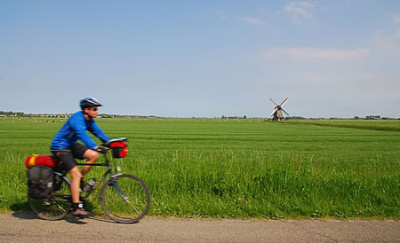 在荷兰骑自行车，有风车的背景