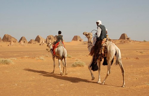 男士在金字塔的骆驼上