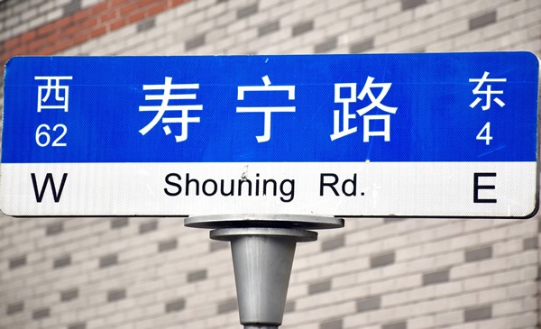 上海的街道标志用英语和普通话书写，并有NWSE标志