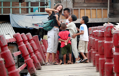 在雅加达，一名妇女向孩子们展示她的相机
