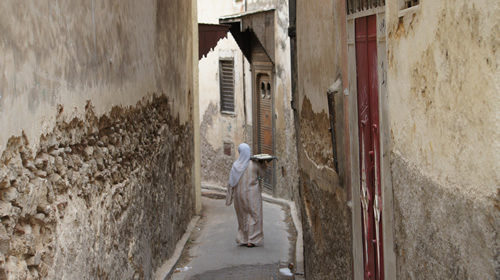 女人在菲斯的麦地那（Medina）将面包带到公共烤箱