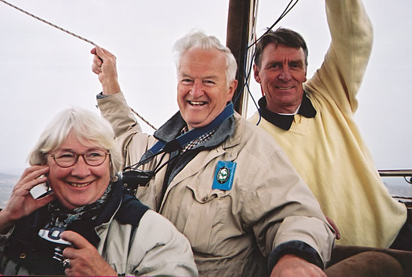 飞行员拉尔斯(右)和年长的旅行者罗比和利兹在气球篮子里放松，在卡帕多西亚上空飞行。